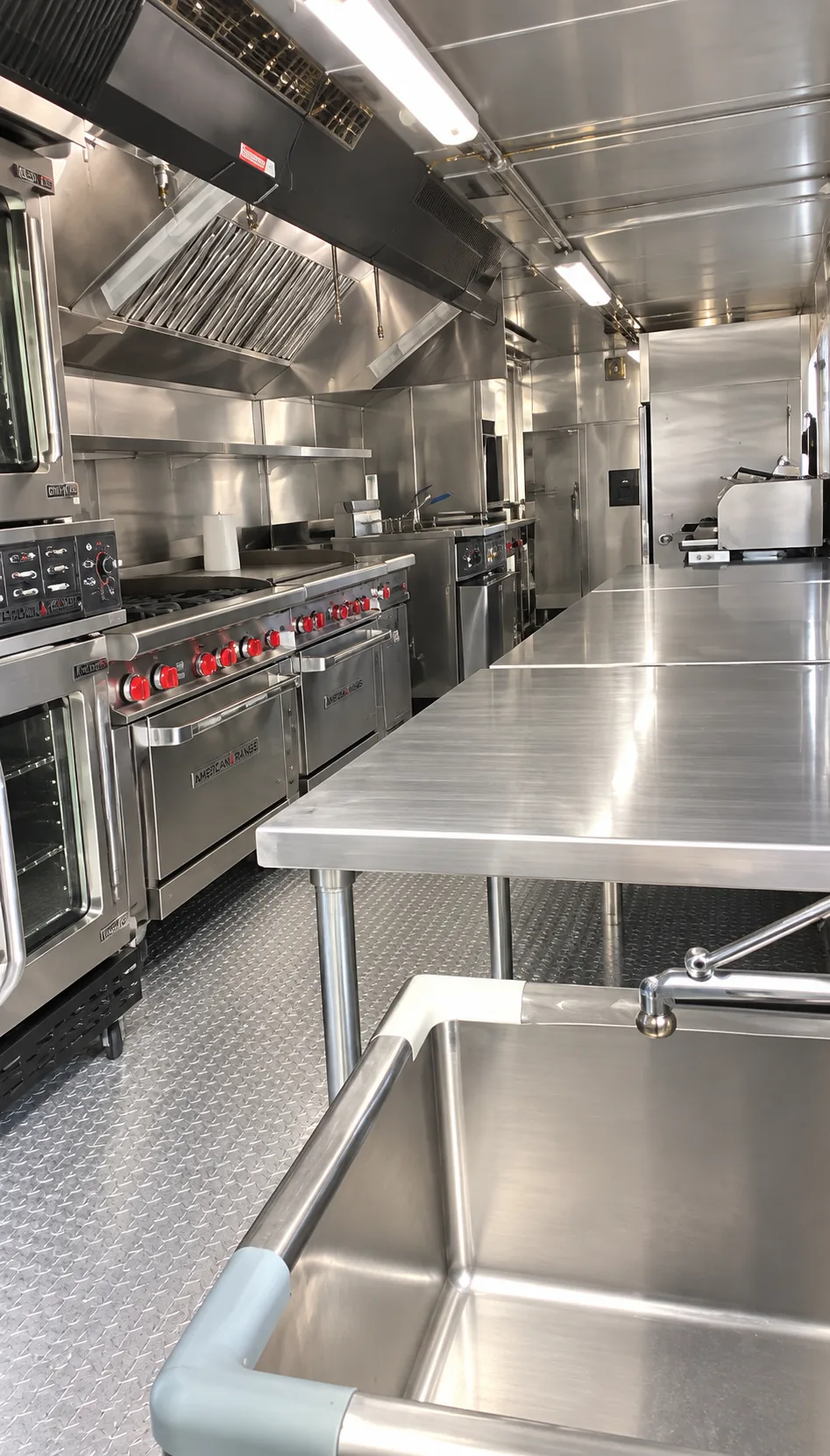 Stainless steel commercial cooking line inside a mobile kitchen trailer